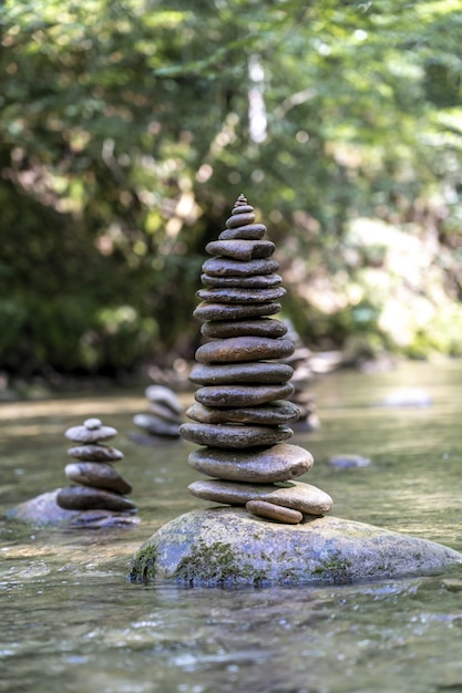 Foto gratuita disparo vertical de muchas pirámides de piedra en equilibrio sobre el agua de un río