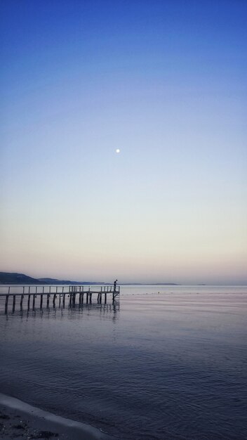 Disparo vertical de un muelle que conduce a una impresionante vista del océano.