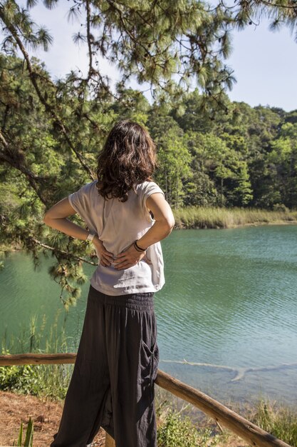 Disparo vertical de una mujer de pie frente al lago de Montebello, Chiapas, México.