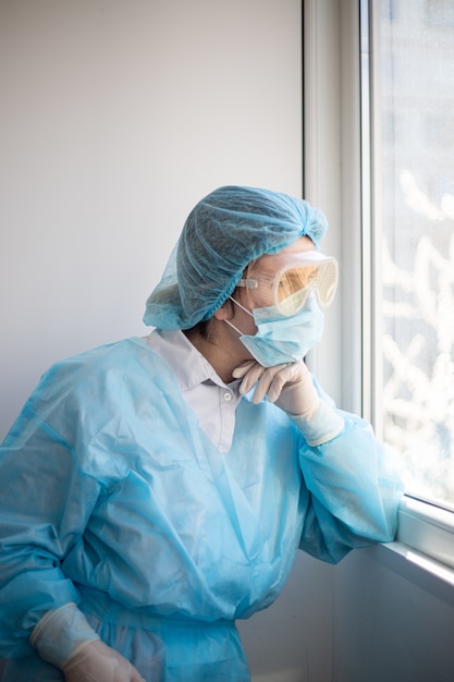 Disparo vertical de una mujer vistiendo un equipo de protección de personal médico