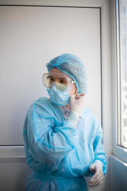 Disparo vertical de una mujer vistiendo un equipo de protección de personal médico