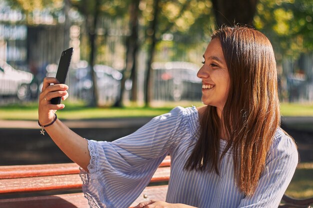 Disparo vertical de una niña con una camisa azul tomando un selfie