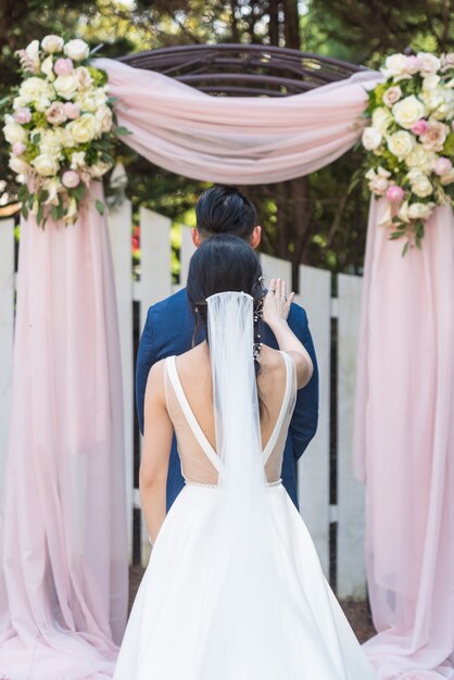 Disparo vertical de una novia y un novio posando en un parque