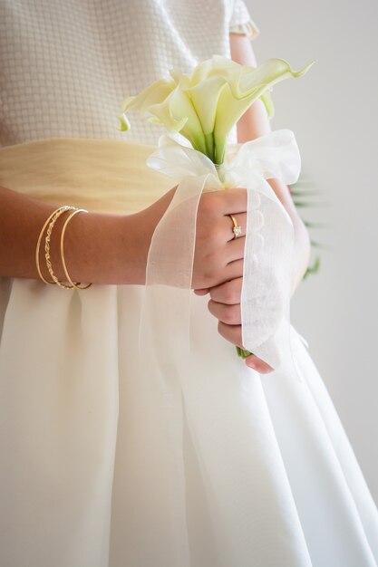 Disparo vertical de una novia sosteniendo un hermoso ramo de novia con flores blancas