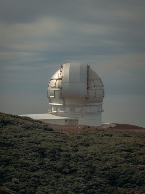 Disparo vertical de un observatorio en una montaña cerca de un campo de hierba