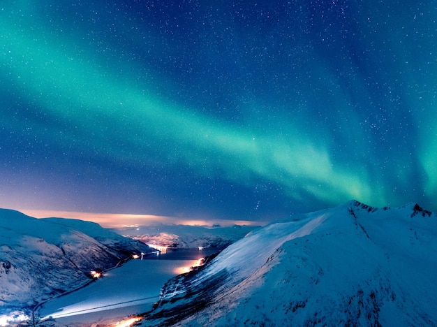 Disparo vertical de un paisaje invernal con la reflexión de la aurora boreal sobre el lago congelado, Tromso