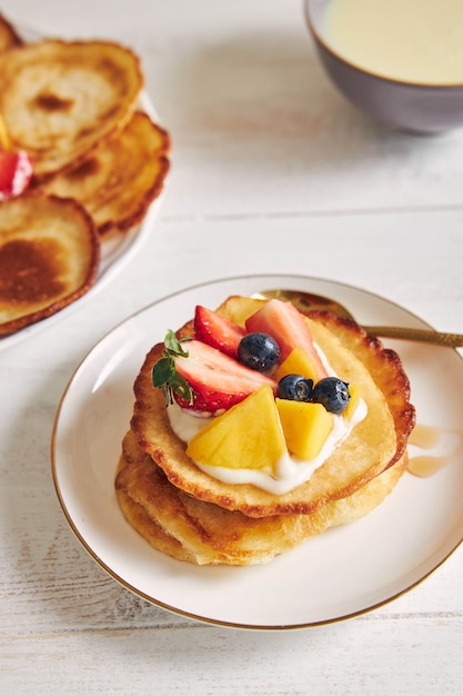 Disparo vertical de panqueques con frutas en la parte superior en el desayuno