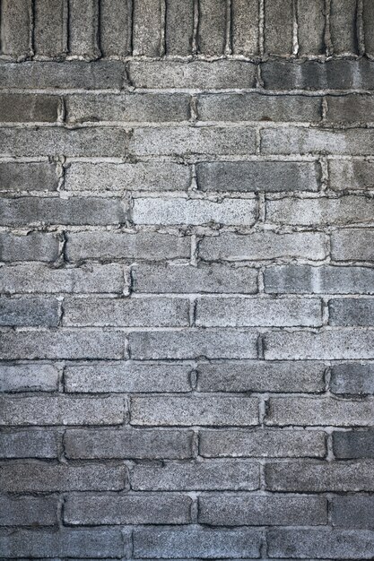 Disparo vertical de una pared de ladrillos grises con cemento