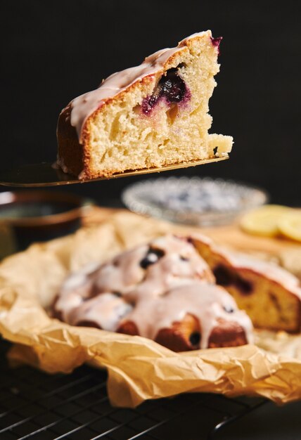 Disparo vertical de un pastel de cerezas con crema e ingredientes en el lado negro