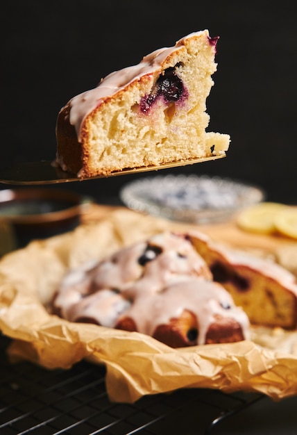 Disparo vertical de un pastel de cerezas con crema e ingredientes en el lado negro