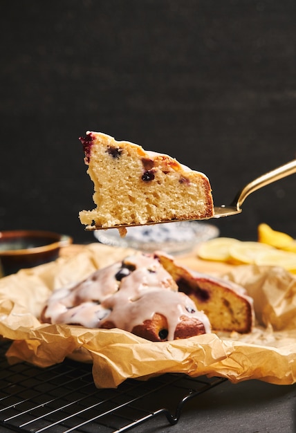 Disparo vertical de un pastel de cerezas con crema e ingredientes en el lateral sobre un fondo negro