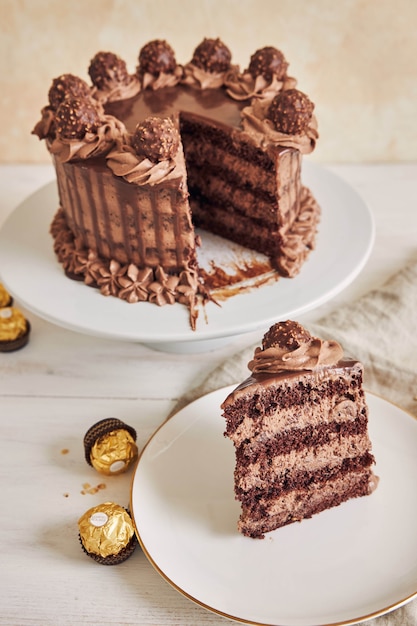 Disparo vertical de un pastel de chocolate y un trozo en un plato junto a algunos trozos de chocolate