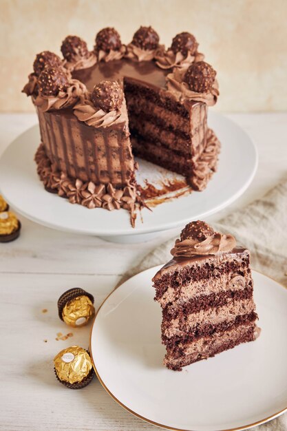 Disparo vertical de un pastel de chocolate y un trozo en un plato junto a algunos trozos de chocolate