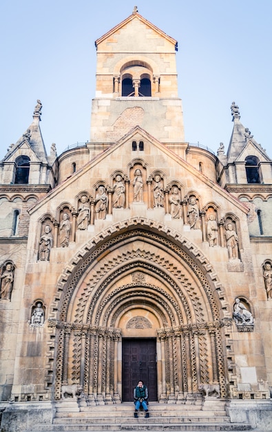 Disparo vertical de una persona sentada en los escalones de la Capilla Jaki en Budapest, Hungría