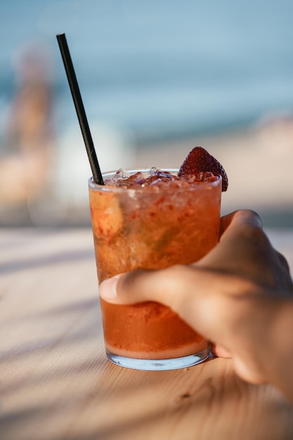 Disparo vertical de una persona sosteniendo un vaso refrescante