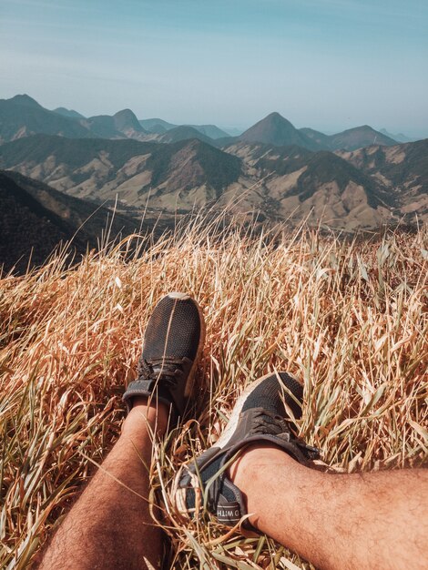 Disparo vertical de pies masculinos y la vista a las montañas en Río de Janeiro.