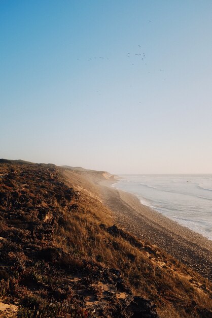 Disparo vertical de playa al amanecer por el mar en calma