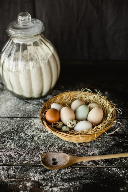 Foto gratuita disparo vertical de pollo fresco y huevos de codorniz en una canasta en una mesa de cocina