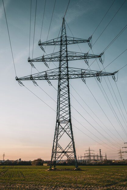 Disparo vertical de un poste eléctrico bajo un cielo nublado azul