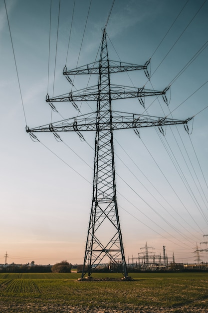 Disparo vertical de un poste eléctrico bajo un cielo nublado azul