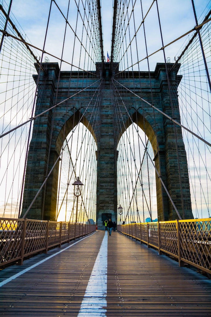 Foto gratuito disparo vertical de un puente de brooklyn en la ciudad de nueva york con una hermosa puesta de sol