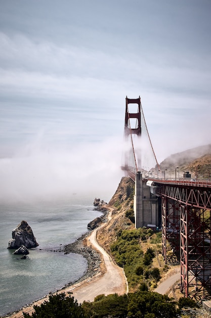 Disparo vertical del Puente Golden Gate contra un cielo azul brumoso en San Francisco, California, EE.