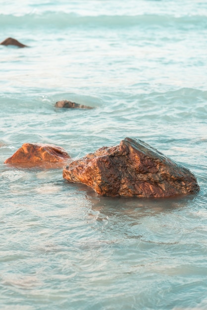 Disparo vertical de rocas en la playa con olas calmantes del océano