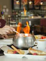 Foto gratuita disparo vertical de una sopa caliente con llamas en una mesa de restaurante