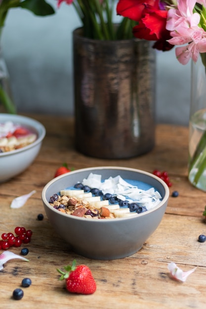 Disparo vertical de un tazón de batido de arándanos saludable con frutas y granola