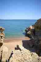 Foto gratuita disparo vertical de therocks en la orilla del mar en la playa pública de playa illa roja en españa