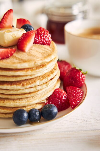 Disparo vertical de tortitas veganas con frutas en la placa blanca.