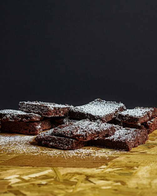 Disparo vertical de trozos de brownie cubiertos de azúcar en polvo sobre una superficie de madera