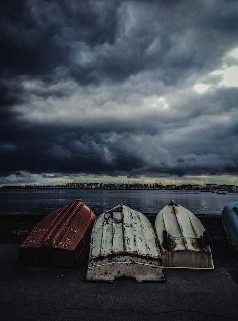 Disparo vertical de viejos barcos de pesca al revés bajo el cielo sombrío