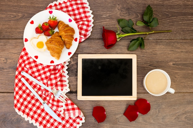 Disposición del desayuno romántico sobre madera.