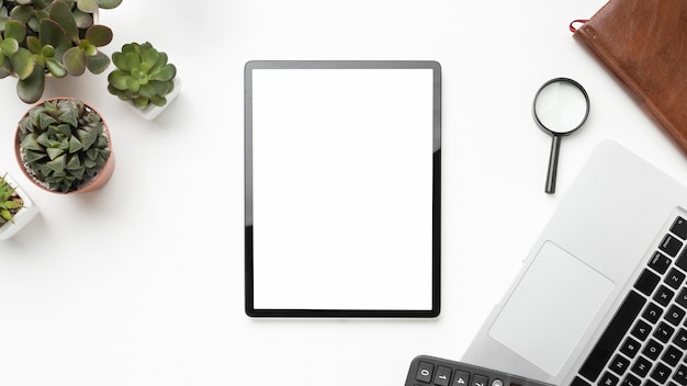 Foto gratuita disposición de elementos de escritorio plano con tableta de pantalla vacía