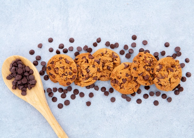 Foto gratuita disposición de galletas rodeadas de chispas de chocolate y cuchara.