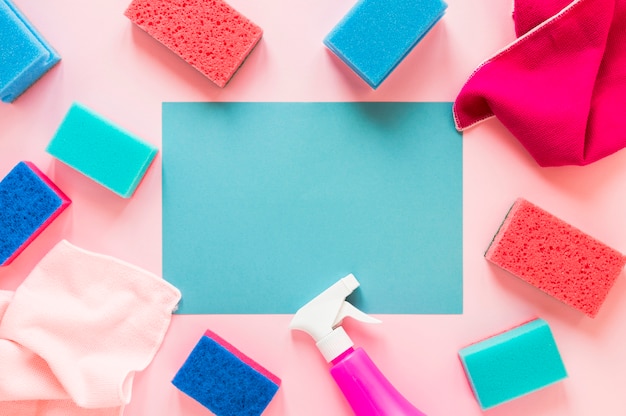 Disposición plana con productos de limpieza sobre fondo rosa