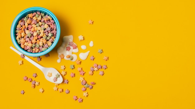 Disposición plana con tazón de cereal sobre fondo amarillo