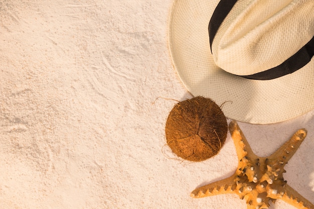 Disposición de verano de sombrero de coco y estrellas de mar en la arena