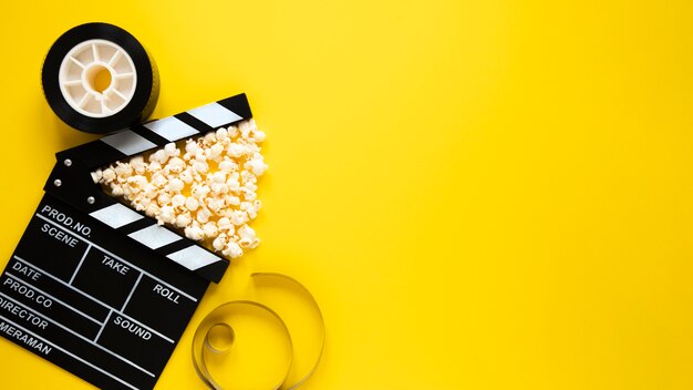 Disposición de la vista superior de elementos de cine sobre fondo amarillo con espacio de copia