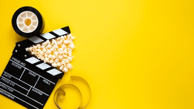 Disposición de la vista superior de elementos de cine sobre fondo amarillo con espacio de copia