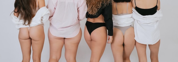 Diversas modelos vistiendo ropa interior de pie de espaldas a la cámara