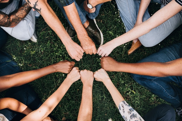 Foto gratuita diversas personas haciendo un golpe de puño en el parque.