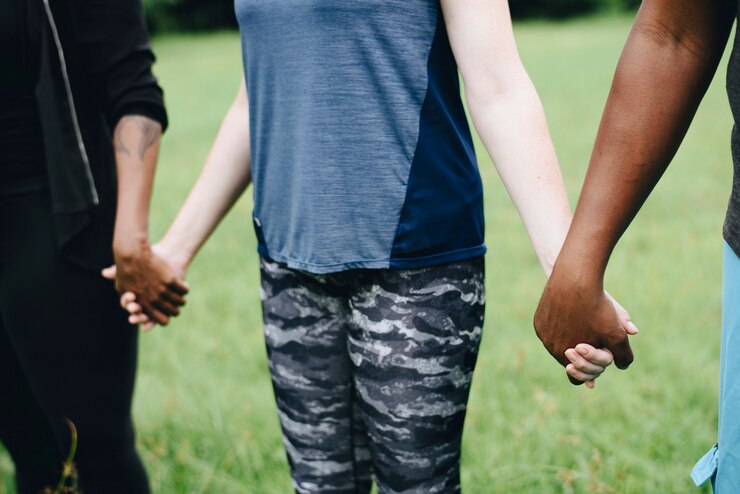 Foto gratuito diversas personas tomados de la mano en el parque