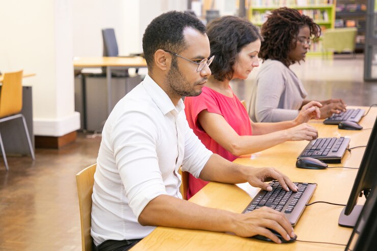 Foto gratuito diversos alumnos realizan exámenes en línea en la clase de computación