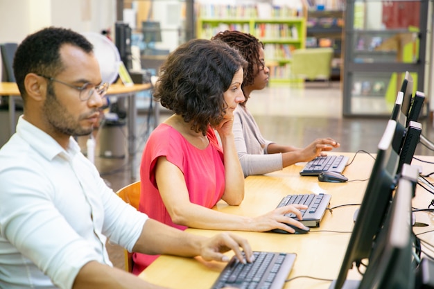Diversos estudiantes adultos que trabajan en la clase de computación