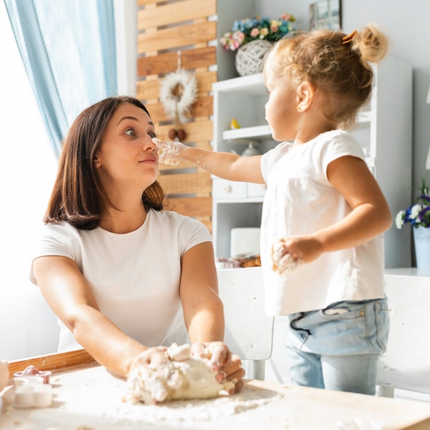 Divertida madre e hija jugando con masa