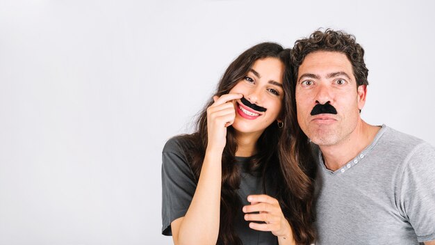 Divertido papá e hija con bigotes