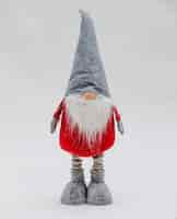 Foto gratuita divertido peluche navideño con forma de gnomo con abrigo rojo y gorro gris en forma de cono