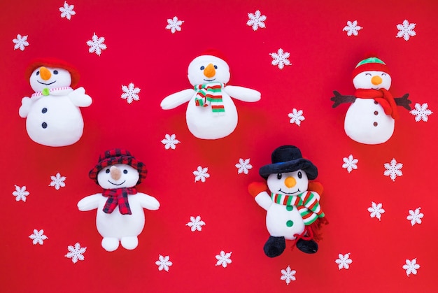 Divertidos muñecos de nieve de juguete entre adornos copos de nieve
